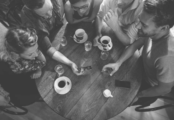 Colleagues gathered around a table with coffee